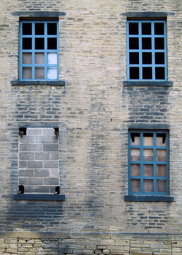 four broken and bricked up windows in a derelict abandoned old h