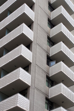 modern white concrete apartment block with geometric angular balconies