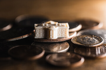 Fototapeta na wymiar A miniature model of the White House in Washington D.C. sitting on some American coins money economy concept