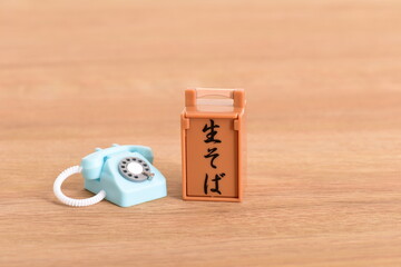 玩具のおかもちと受話器が外れたアナログ電話機
