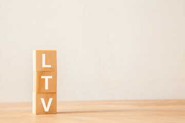 LTVの文字。ライフタイムバリュー。Life Time Value。3つの木製ブロックに書かれている。木製テーブルの背景。