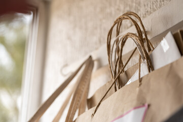 bolsas colgadas a la pared, de tela y de cartón con fondo de ventana abierta