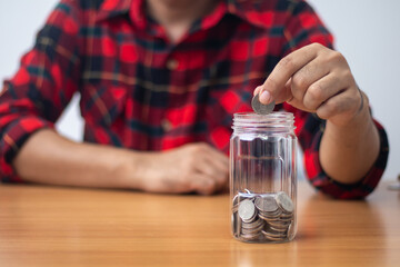 Man holding a coin in a glass (money saving concept)