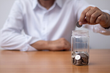 Man holding a coin in a glass (money saving concept)