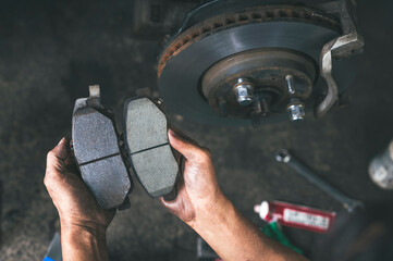 New car brake pads compared to old used brake pads. - obrazy, fototapety, plakaty