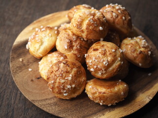 small choux pastry coated with white pearl sugar on wooden plate