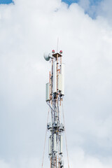 Telecommunication tower of 4G and 5G cellular. Macro Base Station. 5G radio network telecommunication equipment with radio modules and smart antennas mounted on a metal against cloulds sky background.