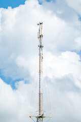 Telecommunication tower of 4G and 5G cellular. Macro Base Station. 5G radio network telecommunication equipment with radio modules and smart antennas mounted on a metal against cloulds sky background.