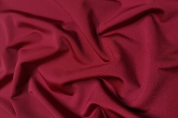 Obraz premium Red supplex crumpled or wavy fabric texture background. Abstract linen cloth soft waves. Silk fabric. Smooth elegant luxury cloth texture. Concept for banner or advertisement.