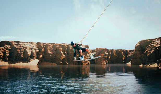 Wakeboarder making tricks on the river. Wakeboarding. Water sports.