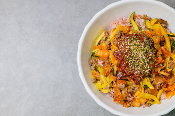 Korean food Bibimbap, Rice topped with sautéed beef and a variety of colorful vegetables that is mixed at the table with spicy gochujang. A hint of sesame oil helps bring out the flavor.