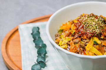 Korean food Bibimbap, Rice topped with sautéed beef and a variety of colorful vegetables that is mixed at the table with spicy gochujang. A hint of sesame oil helps bring out the flavor.
