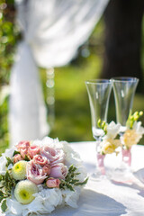 Bright bouquet and wedding glasses on the table