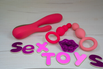 sex toys phrase letters next to various sex pleasure toys, sex shop idea