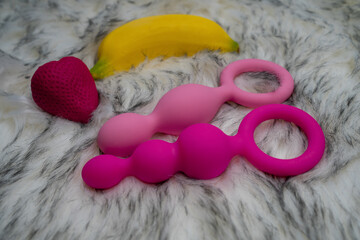 different sex toys with fruits on gray background, sexy atmosphere 