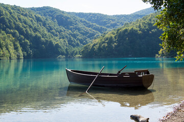 Fototapeta na wymiar boat on the lake, in the background mountains, croatia