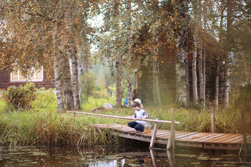 A child is fishing in the autumn morning. Autumn sunset on the pond. A fisherman with a fishing rod on the walkway.