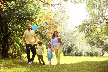 Naklejka na ściany i meble Family with children for a walk in the summer park. Сoming autumn in the park. Family. Fall. Happiness.