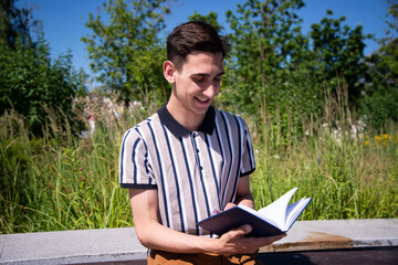 Fototapeta premium Education and entertainment. Young attractive student with a book. Happy man. 