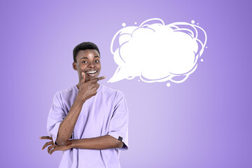 African businessman smiling with finger pointing to mockup speech bubble