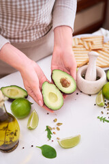 Making avocado toast - Woman hold fresh ripe halved avocado