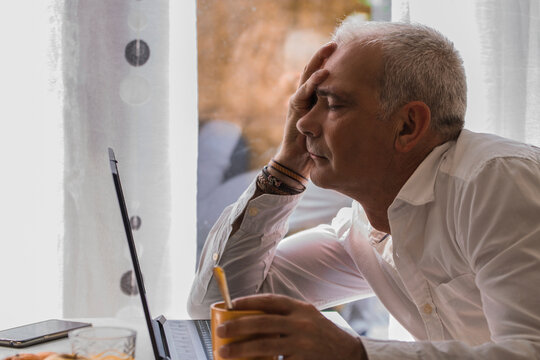 man having breakfast and depressive or bored in front of the laptop