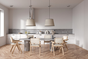 Light kitchen interior with eating table and chairs on wooden floor