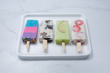 A view of several colorful paletas on a tray. - obrazy, fototapety, plakaty