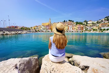 Afwasbaar Fotobehang Nice Vacation relax. Girl sitting on stone enjoying landscape of French Riviera on sunny day, Menton, France.