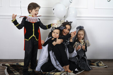 Fototapeta premium Happy family with children in costumes of witch and vampire in a house in holiday Halloween