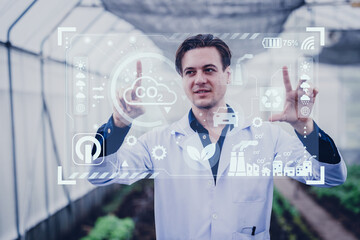 Scientist male researcher looking visual display overlay information data in agriculture farm. Agricultural Science and Technology concept.