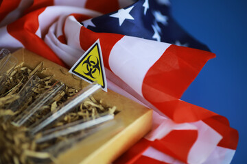 Fototapeta na wymiar American flag and biohazard sign. The concept of American biolabs and research centers.