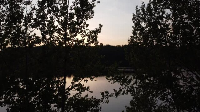 Sunset over a forest lake, in the background the Czocha castle and boats on the water