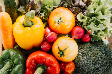 female farmer working early on farm holding wood basket of fresh vegetables and tablet