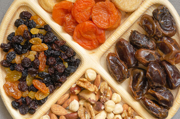combined plate with dried fruits and nuts. in each compartment of the plate there is food