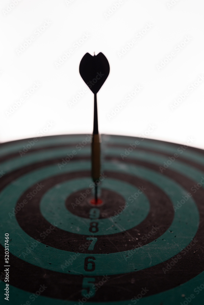 Poster close up shot of the dart arrow hit on bulleyes of dartboard to represent that the business reached 