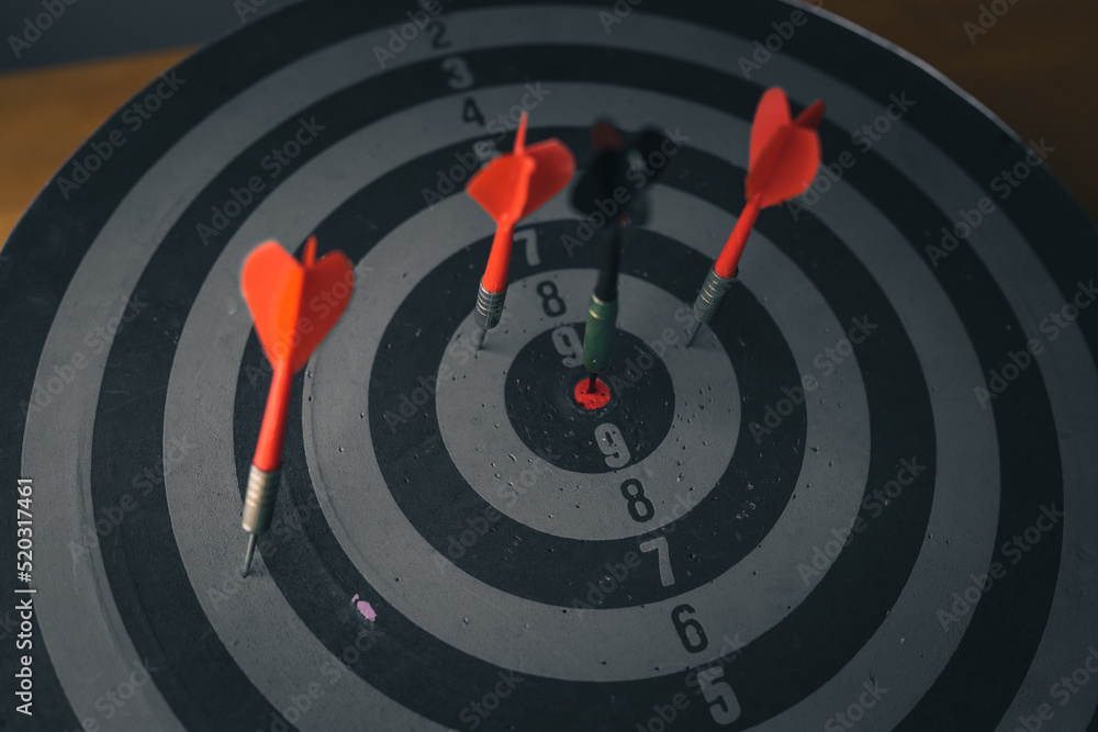 Poster close up shot of the dart arrow hit on bulleyes of dartboard to represent that the business reached 