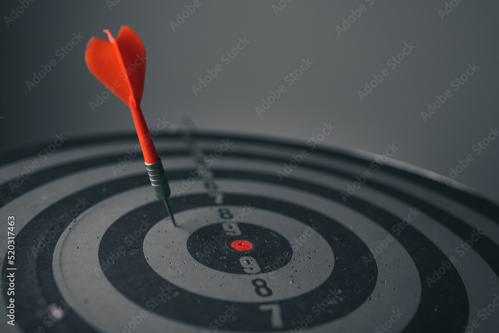 Poster close up shot of the dart arrow hit on bulleyes of dartboard to represent that the business reached 