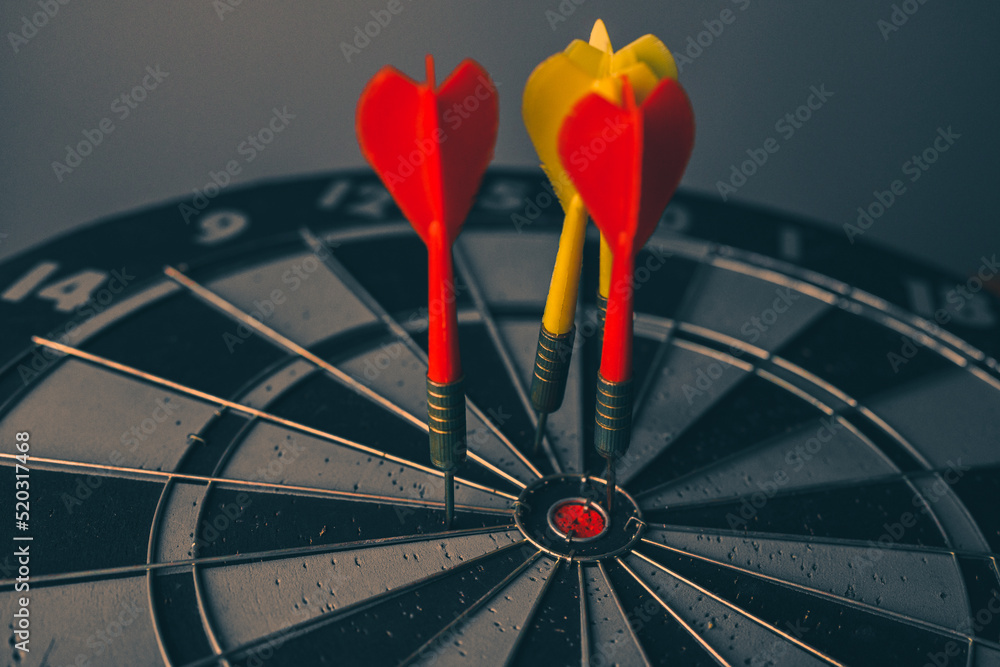 Poster close up shot of the dart arrow hit on bulleyes of dartboard to represent that the business reached 