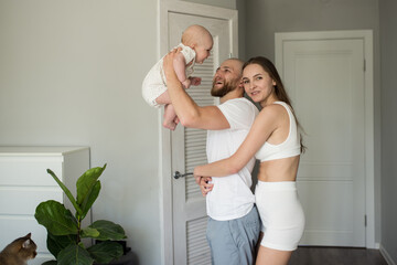Happy family. Portrait of caucasian smiling mother father and newborn baby hugging at home. Motherhood. Loving parents mom and dad enjoy taking care of a little child. healthy child care