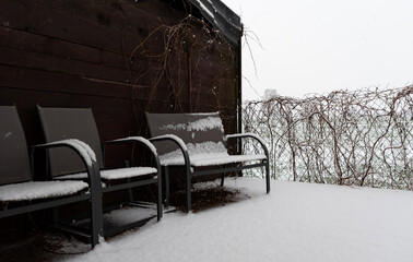 Fototapeta na wymiar Garden furniture under the snow. Winter precipitation and a thick layer of snow on the garden furniture.