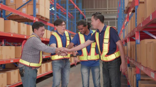 Professional, teamwork and Unity of group warehouse workers in factory storehouse. Colleague, manager and employee standing hands holding together celebrate cheerful success with happy smile.