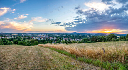 Fototapeta na wymiar Saarland – Panorama Blick auf St. Wendel und Landschaft mit Feld im Sonnenuntergang