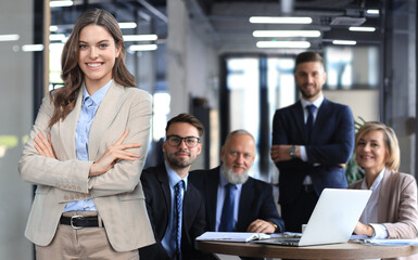 Confident stylish european middle aged woman standing at workplace, executive leader manager looking at camera.