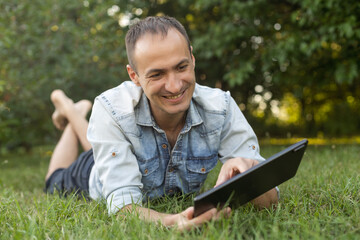 a man uses a tablet to chat in the garden