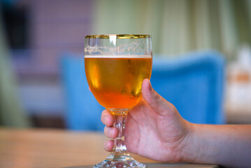 Man holding a beautiful glass of light beer