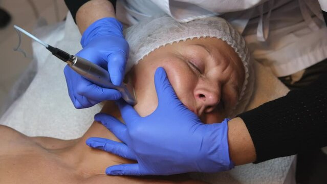 Middle-aged woman doing anti-aging cosmetic procedures in a beauty salon. Mature woman taking care of her face and body. Anti-aging procedure.