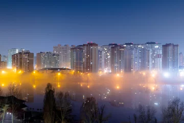Photo sur Plexiglas Kiev Night cityscape of the big city. Awesome bright, multi colored light in thick fog at empty streets. Apartment buildings in bedroom community, commuter town area. Darnytsia, Kyiv. Ukraine. 2021