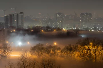 Deurstickers Night cityscape of the big city. Awesome bright, multi colored light in thick fog at empty streets. Apartment buildings in bedroom community, commuter town area. Darnytsia, Kyiv. Ukraine. 2021 © Sodel Vladyslav