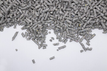 shallow depth of field photo of recycled Paper cat litter pellets on a white background